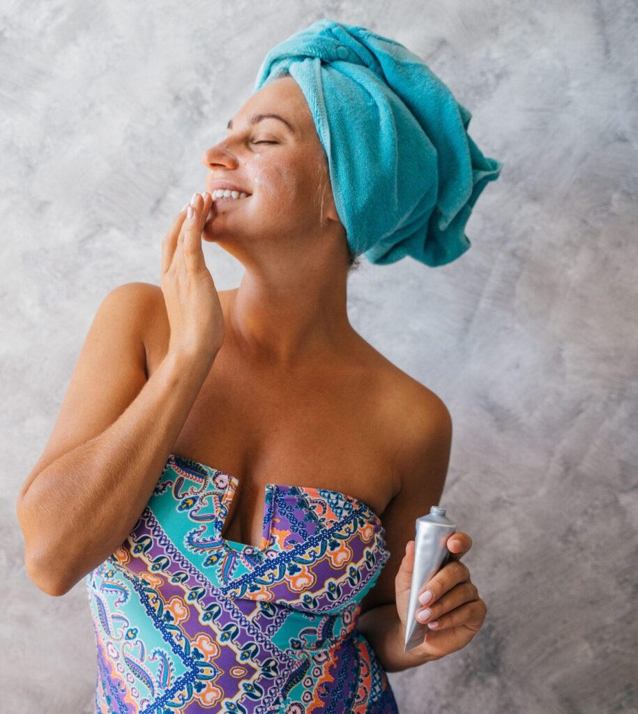 simple summer skincare routine - woman applying SPF and skincare products outdoors