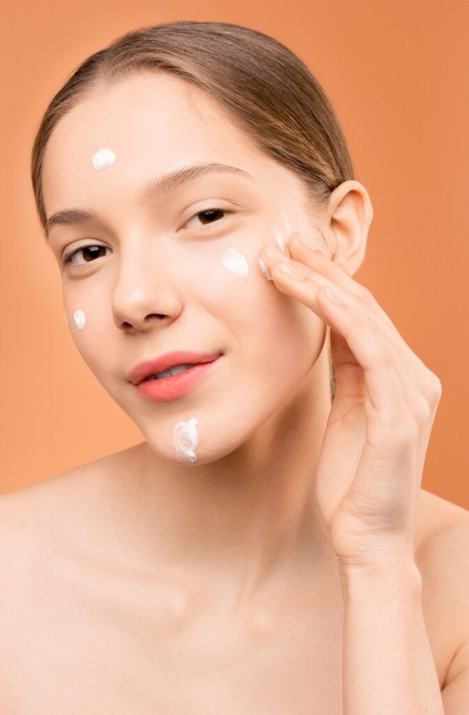 skin barrier repair - woman applying moisturizer to hydrated, healthy-looking skin